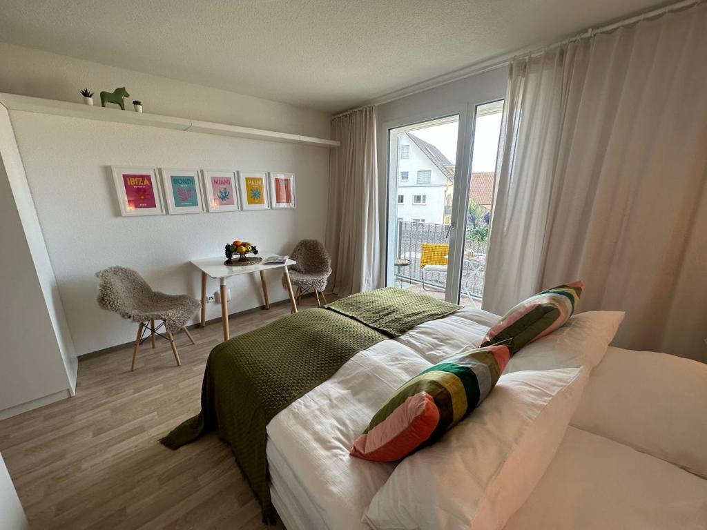 Komfortables, barrierefreies Appartement mit sonnigem Balkon in der Nähe von Flughafen und Messe 30 في لاينفيلدن-إشتردينغن: غرفة نوم بسرير وطاولة ونافذة