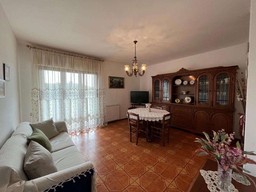 Appartamento Incantevole a Follonica Mare- 5 posti في فولونيكا: غرفة معيشة مع أريكة وطاولة