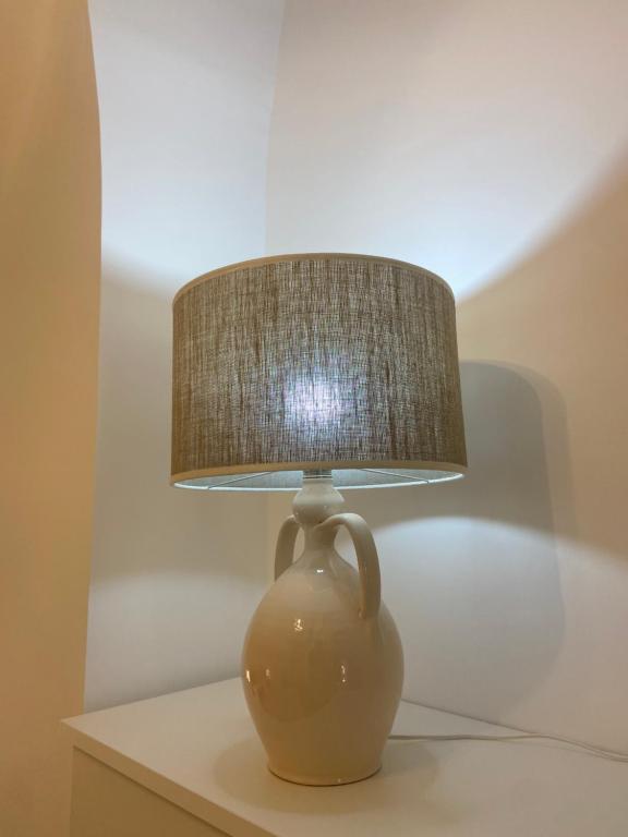 a brown vase sitting on a table with a lamp at Dimora Nonno Ciccio in Polignano a Mare