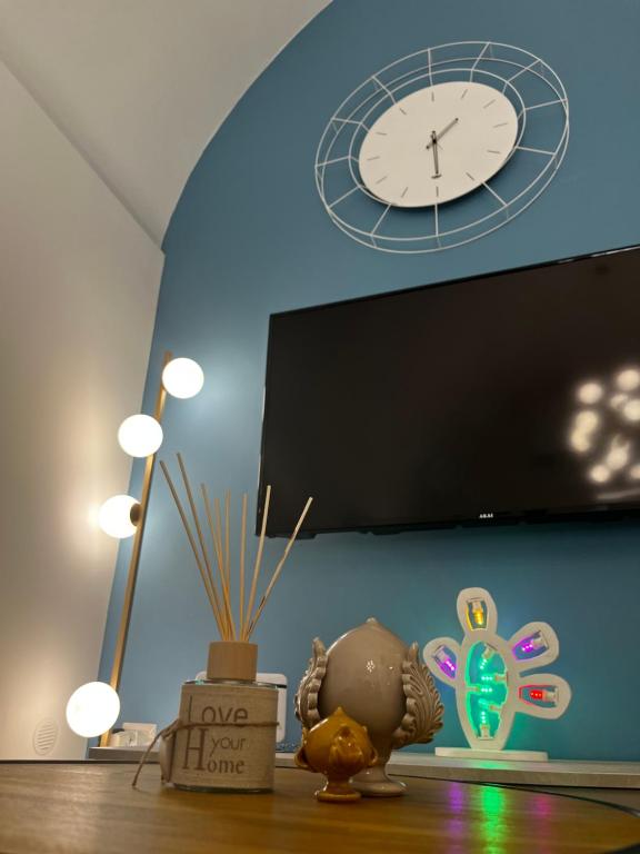 a clock on a wall above a table with some items at Dimora Nonno Ciccio in Polignano a Mare