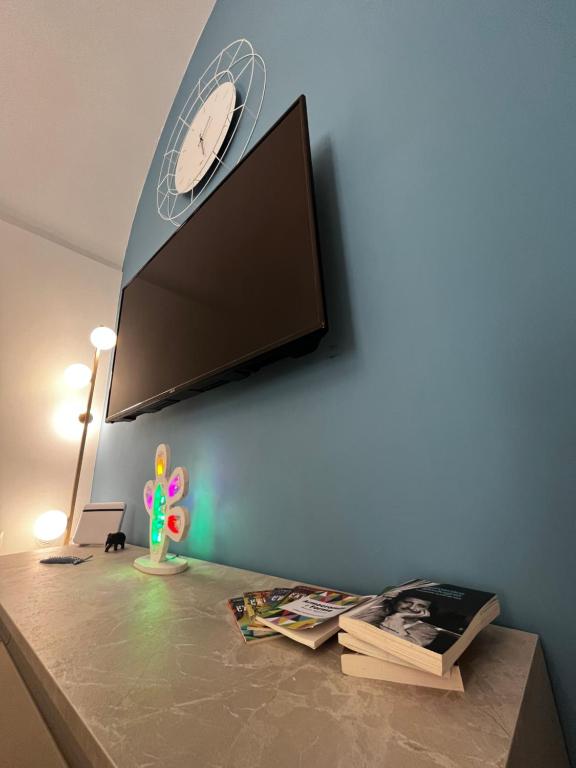 a tv on a wall with a clock on a wall at Dimora Nonno Ciccio in Polignano a Mare