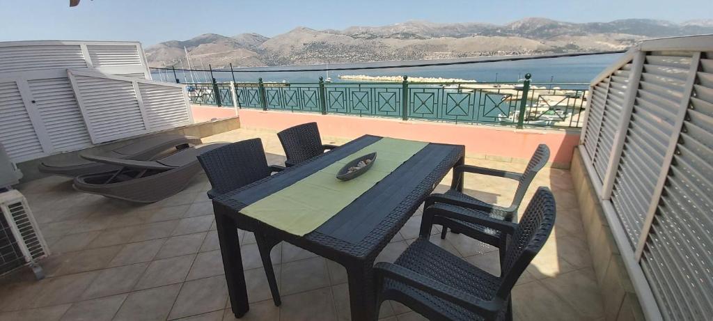 a table and chairs on a balcony with a view of the ocean at Johanna Sea View Apartment in Lixouri