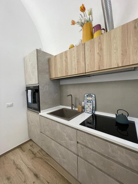 a kitchen with a sink and a microwave at Dimora Nonno Ciccio in Polignano a Mare