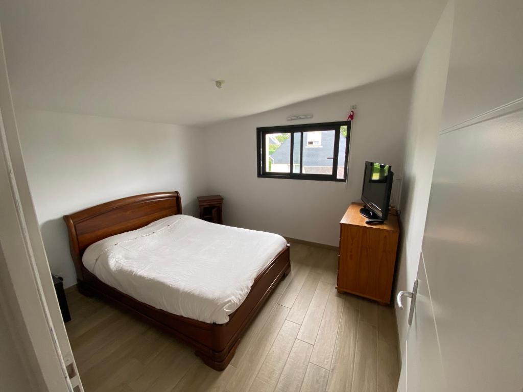 a small bedroom with a bed and a television at Maison chaleureuse chez l’habitant avec parking in Theix