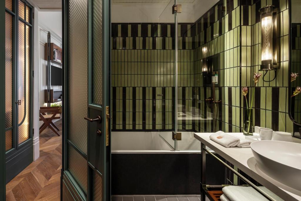 een badkamer met een bad, een wastafel en een bad bij The George Tel Aviv in Tel Aviv