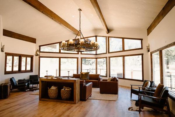 a living room with a couch and a chandelier at The Lodge at Silver Ridge Ranch in Cabin Creek