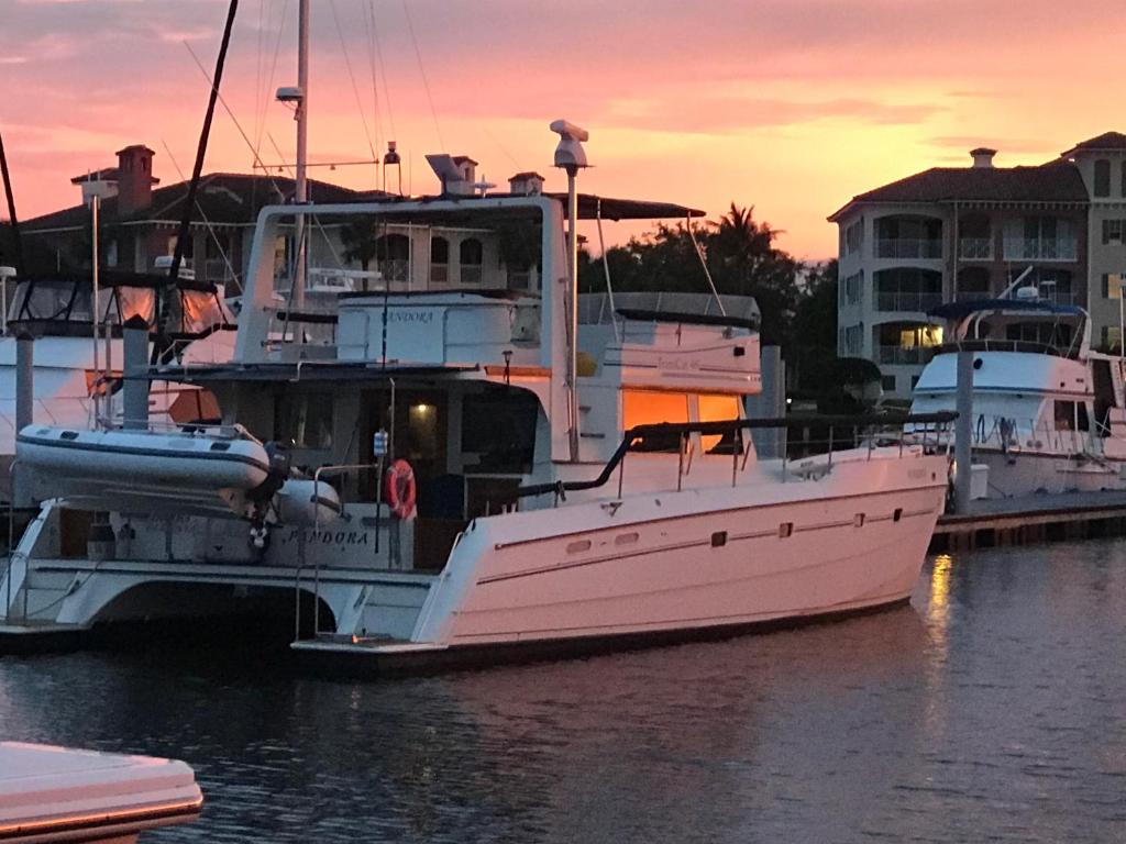 un barco rosa está atracado en el agua en Disney Orlando Catamaran Accommodation en Vero Beach