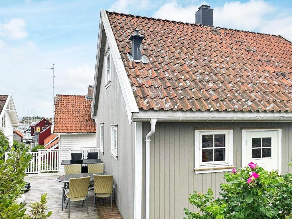 Casa blanca con patio con mesa y sillas en Holiday home Skjærhalden, en Skjærhollen