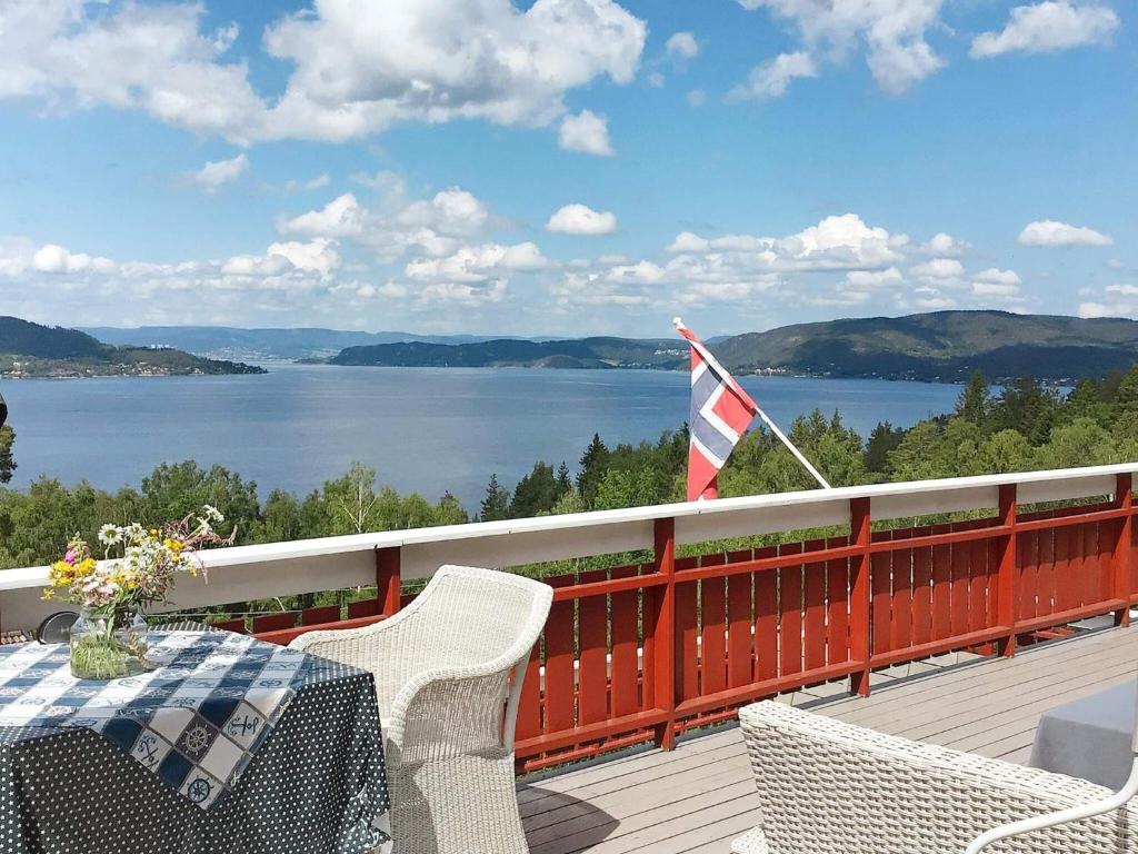 einen Tisch und Stühle auf einer Terrasse mit Blick auf das Wasser in der Unterkunft Holiday home Klokkarstua in Svelvik