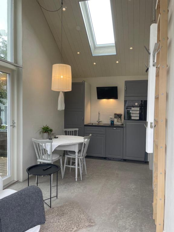 a kitchen and dining room with a table and chairs at Lilla kyrkhuset på Råå in Helsingborg