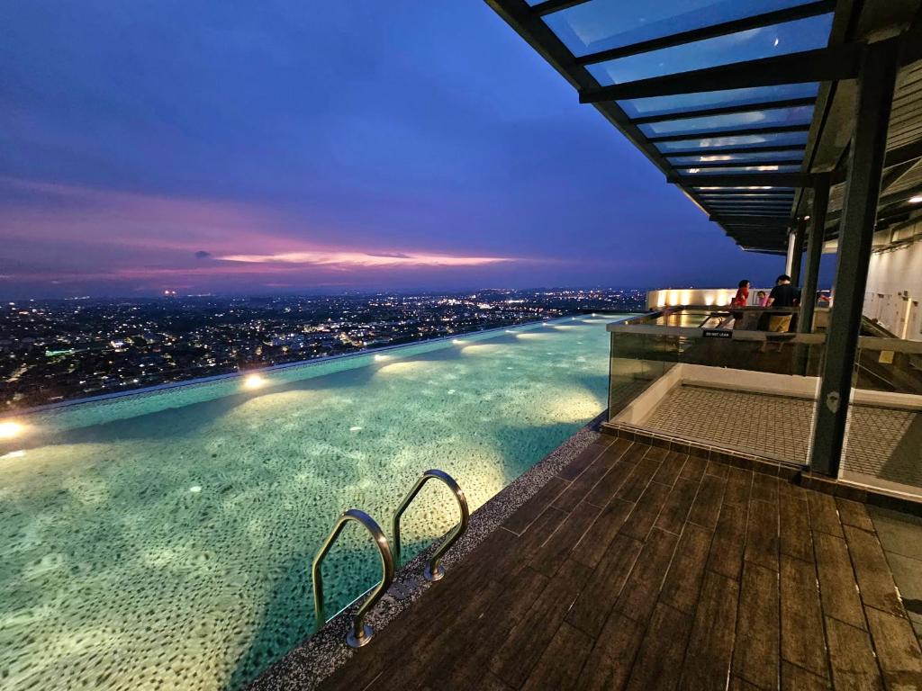 a swimming pool on top of a building with a city skyline at The Quartz Residence - Melaka in Melaka