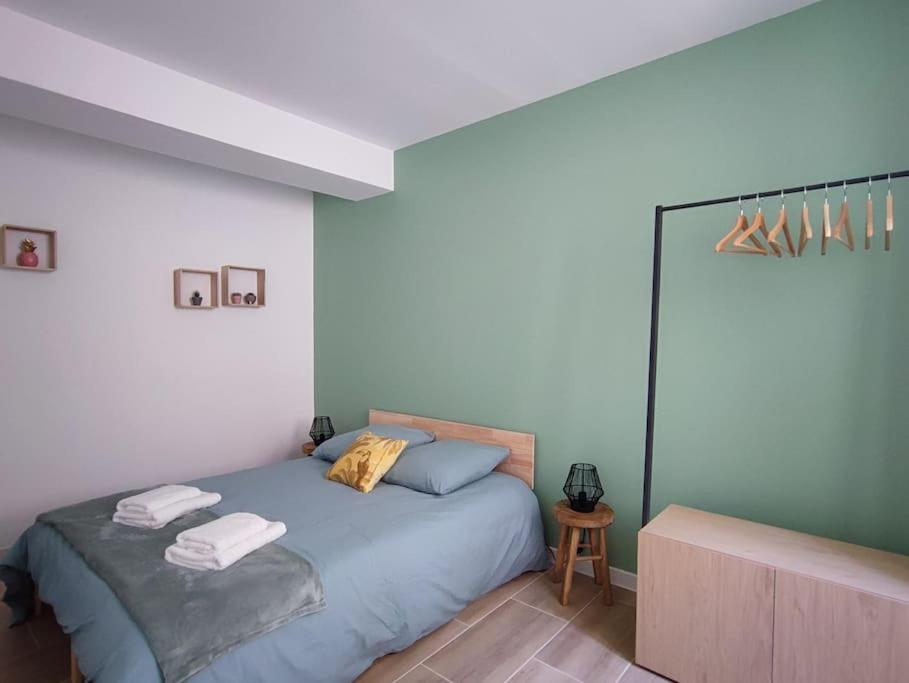 een slaapkamer met een bed met twee handdoeken erop bij Jardin entre cité et bastide in Carcassonne