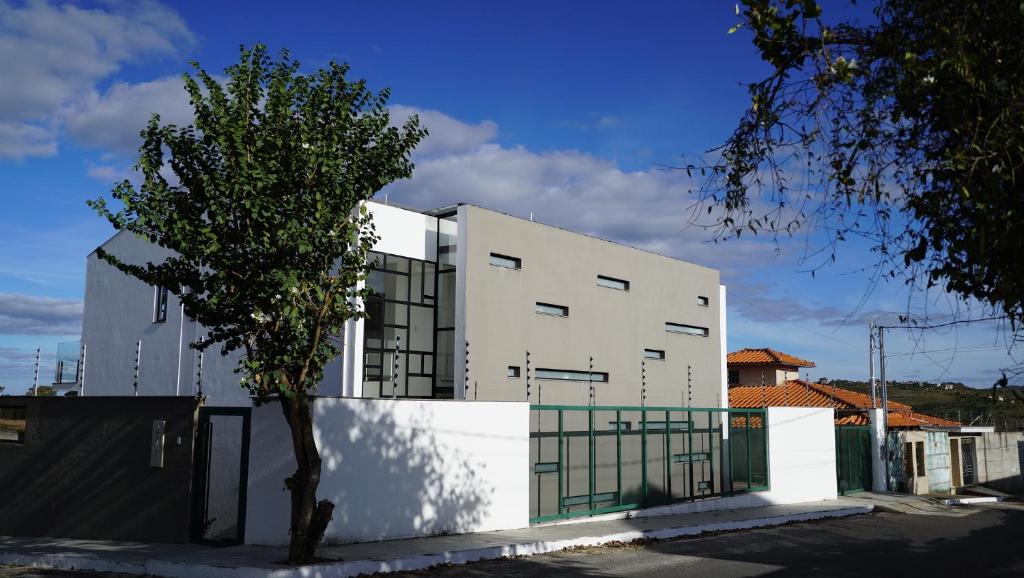 un bâtiment blanc avec un arbre devant lui dans l'établissement Casa do Sol, à Diamantina