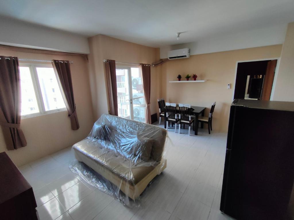 uma sala de estar com um sofá de couro e uma mesa em Made Residence and Apartment em Surabaya