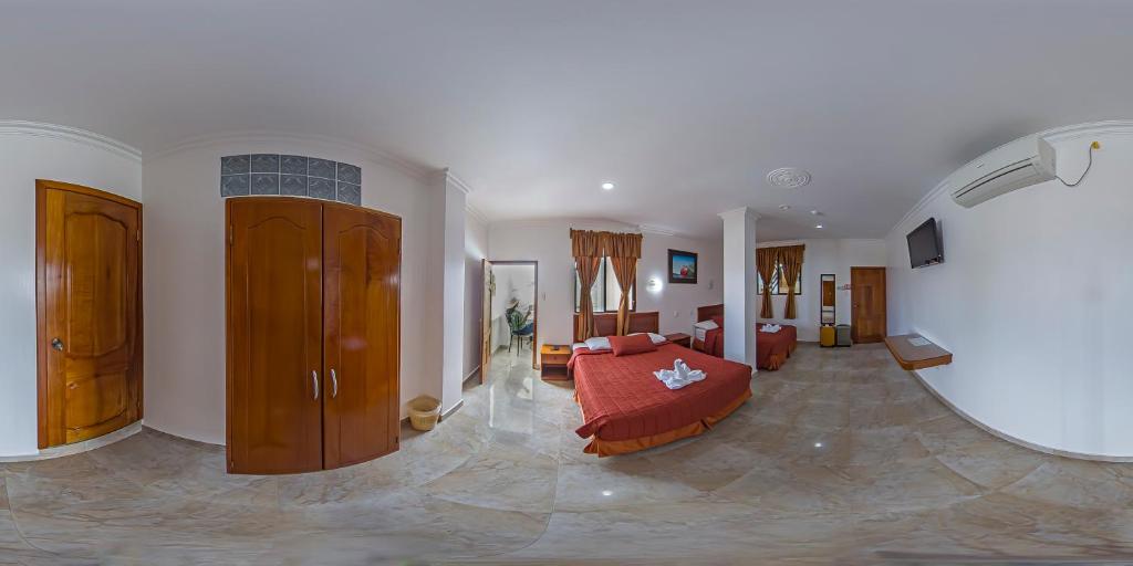 sala de estar amplia con cama y sofá en Hostal España, en Puerto Ayora
