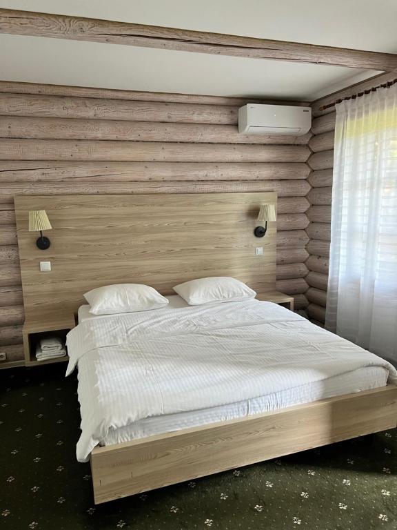 a bedroom with a large bed with a wooden headboard at Vik-Jan in Khmelʼnytsʼkyy