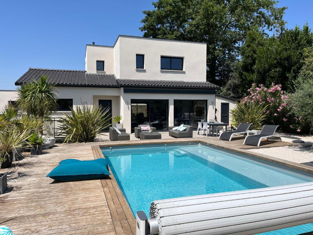 una casa con piscina frente a una casa en Villa Les Palmiers, en Flourens