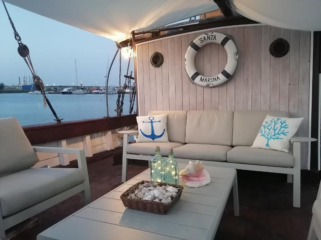 Corabia Santa Marina في سولينا: غرفة معيشة مع أريكة وطاولة على قارب