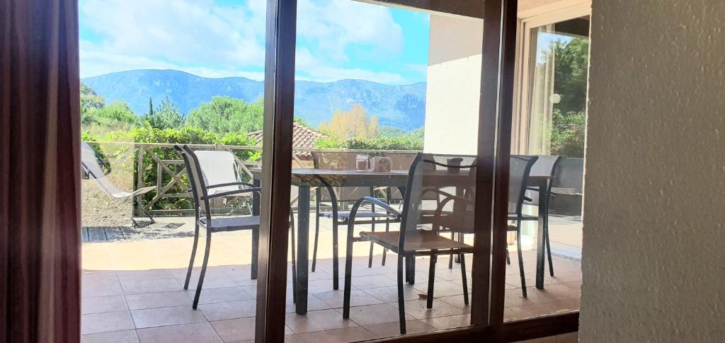 uma varanda com mesa e cadeiras e vista para as montanhas em Babaji Villa de prestige - Quillan em Quillan