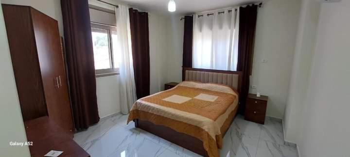 1 dormitorio con 1 cama en una habitación con ventana en شقة CRESTAL, en Amán