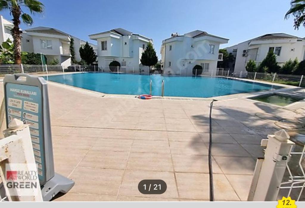 a swimming pool in front of some houses at Denize 800 m villamız in Aksu