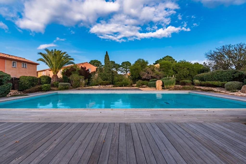 a swimming pool in a yard with a wooden deck at Plage à pied : Mini villa Saint-Cyprien in Lecci
