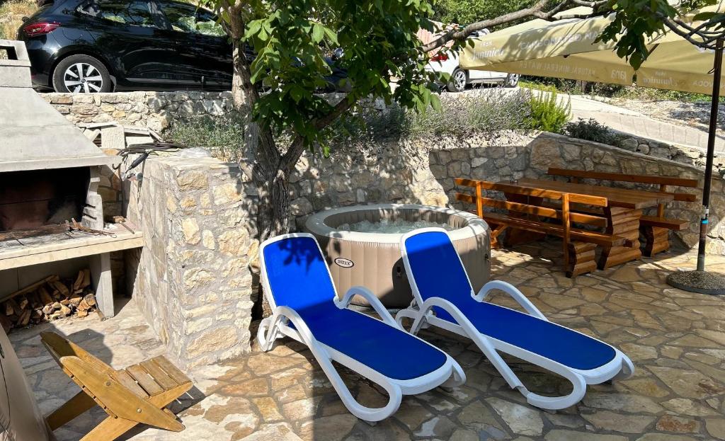two blue chairs sitting next to a fountain at Stone house Marinko - Free Beach Parking in Tučepi