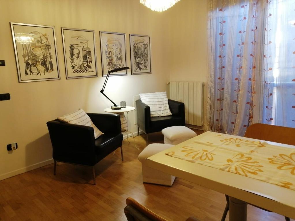 - un salon avec une table et des chaises dans l'établissement Appartamento Angela, à Cento