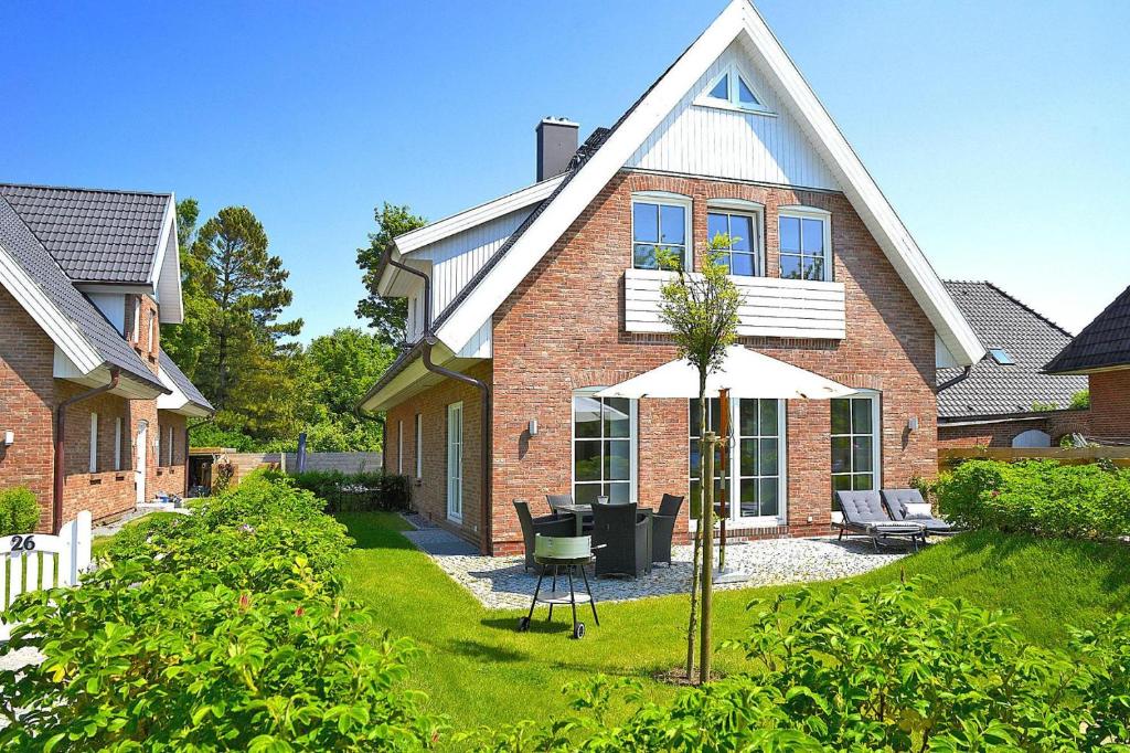 una casa con un paraguas en el patio en Ferienwohnung in Wyk auf Foehr, en Wyk auf Föhr