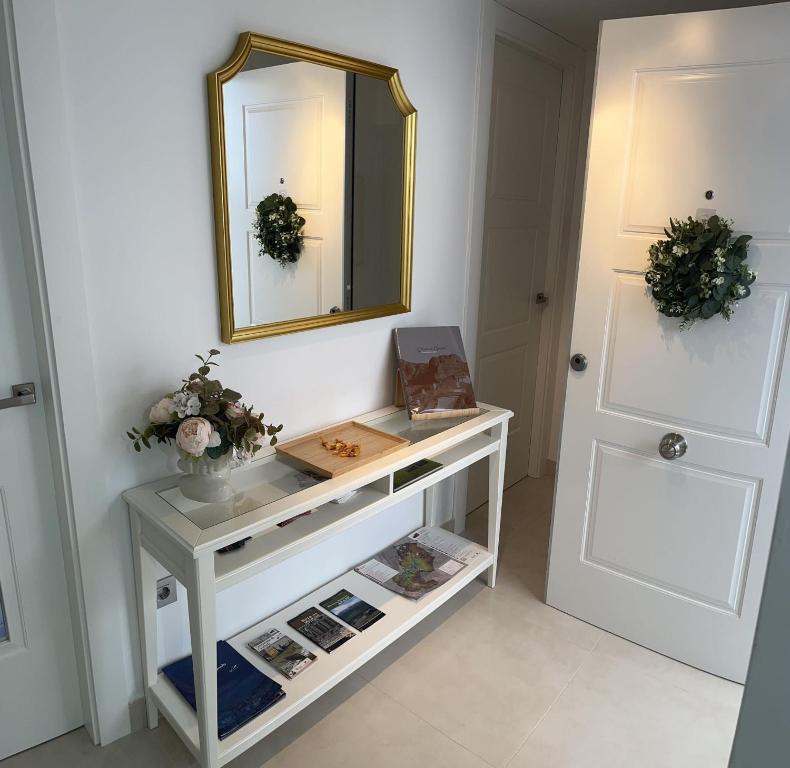 um toucador branco com um espelho e uma porta em Apartamento Turístico Julia Gemella Acci em Guadix