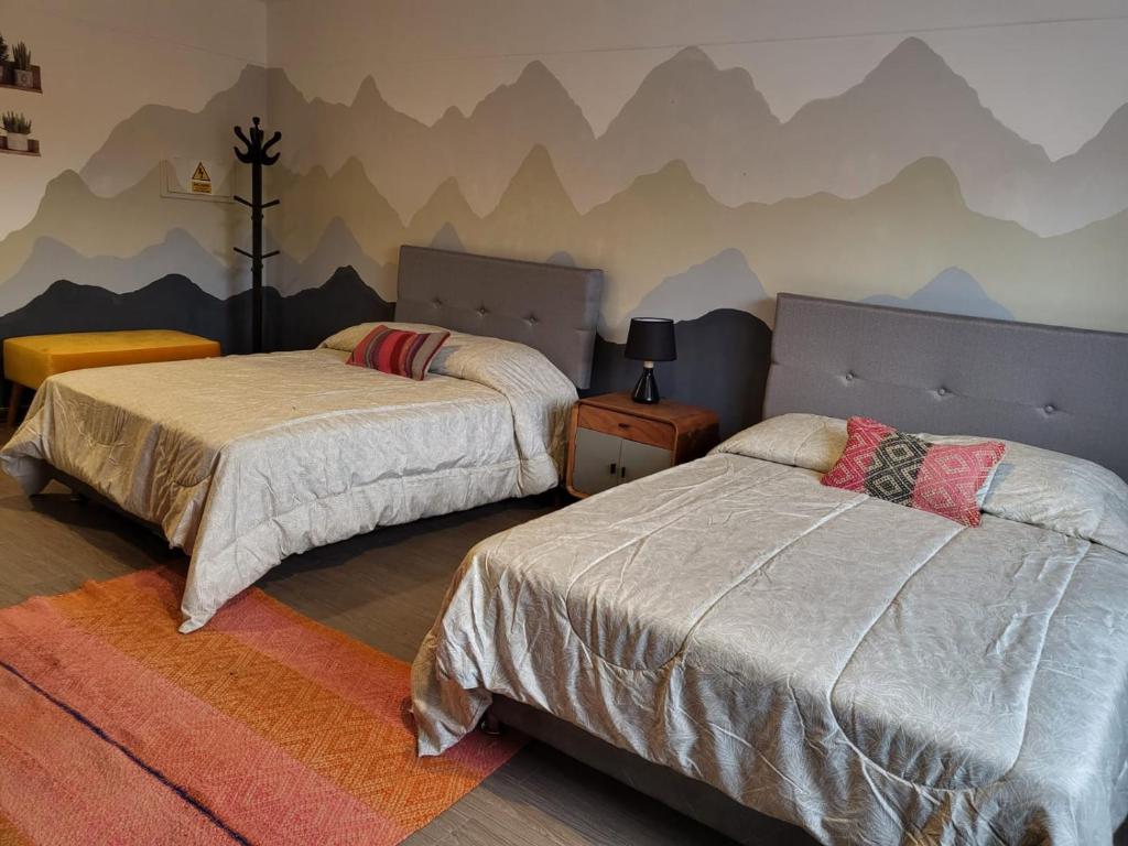1 dormitorio con 2 camas y un mural de montaña en la pared en Alojamiento San Francisco Preciosas habitaciones con baño privado, en Lima