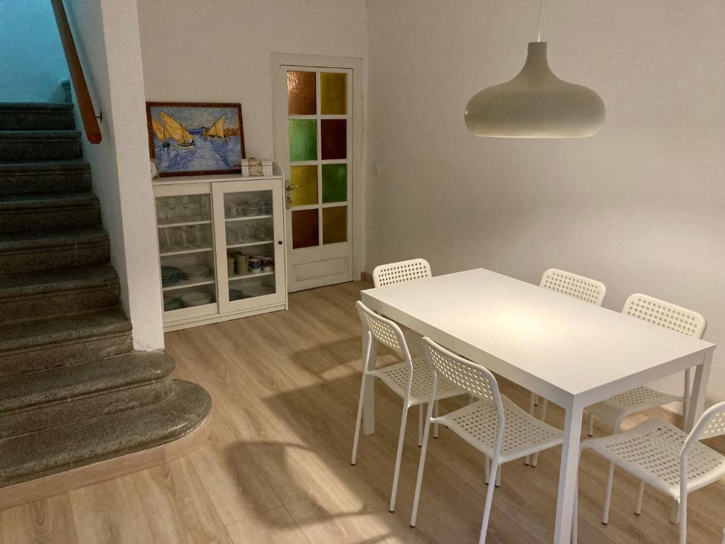 ein Esszimmer mit einem weißen Tisch und Stühlen in der Unterkunft Can Julián in L'Escala