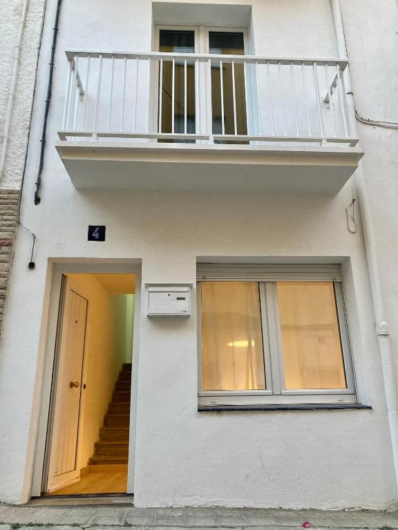 a white building with a balcony and a staircase at Can Julián in L'Escala