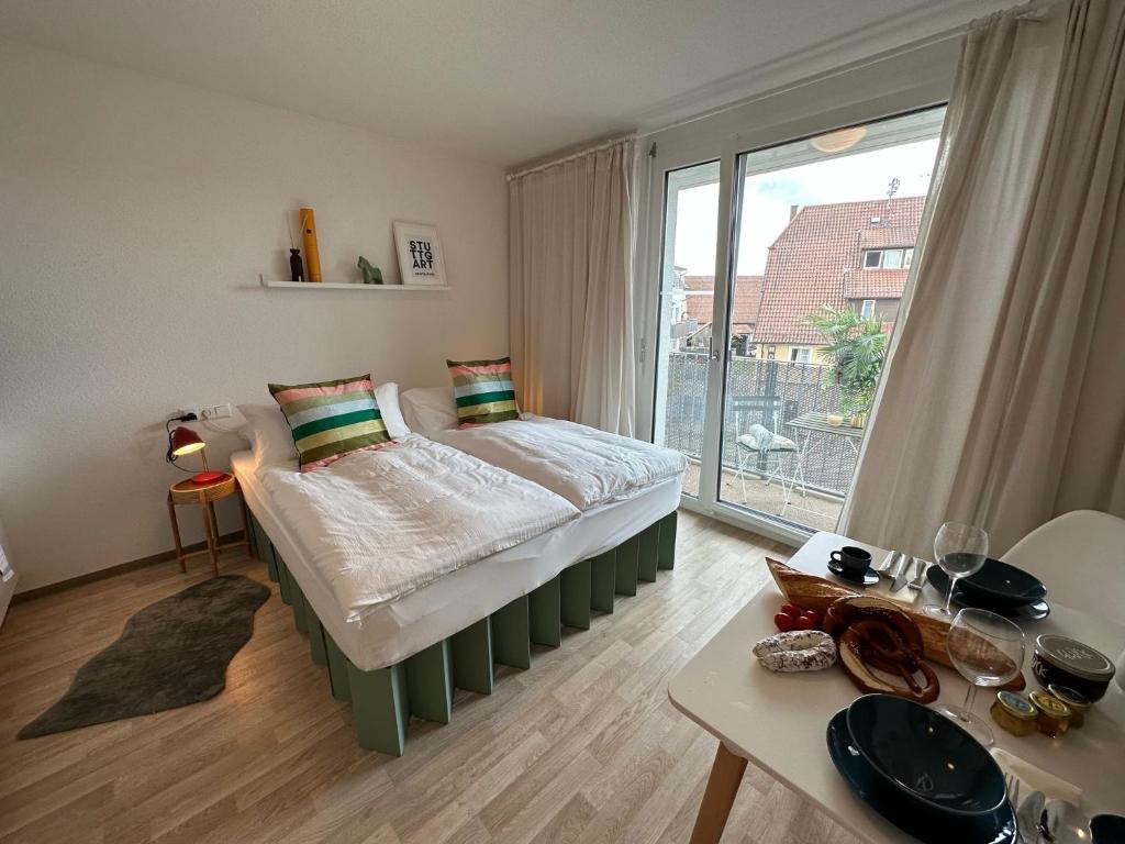 - une chambre avec un lit et une grande fenêtre dans l'établissement Stilvolles und modernes Appartement mit sonnigem Balkon in Flughafen- und Messenähe 31, à Leinfelden-Echterdingen