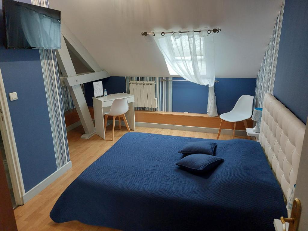 Dormitorio azul con cama y escritorio en AU FIL DES LACS, en Précy-Saint-Martin