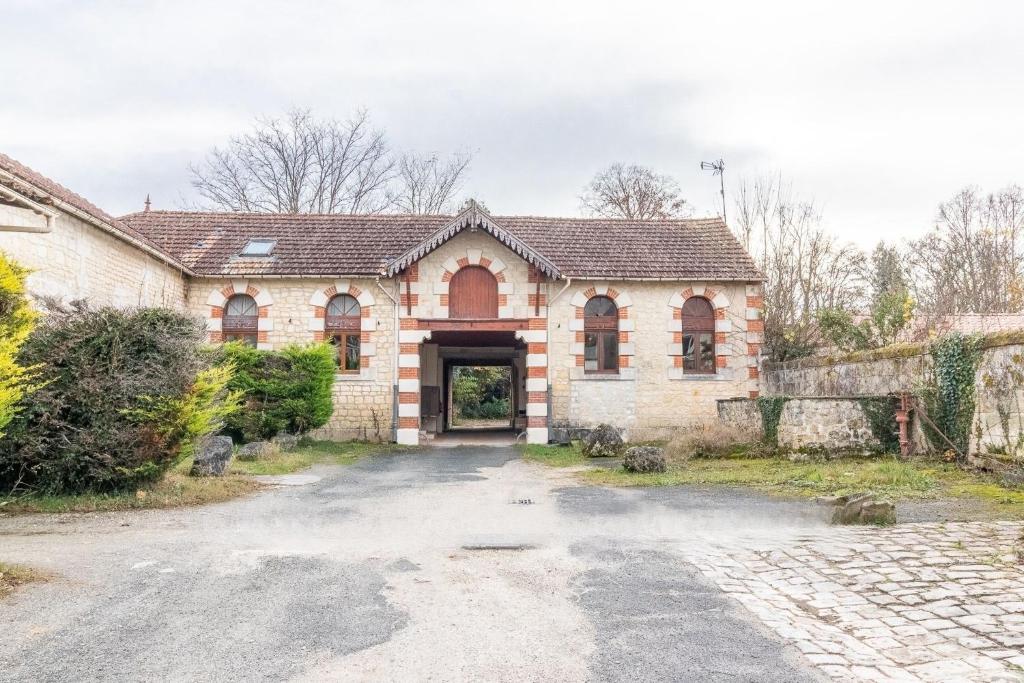 an old stone house with a driveway at LA BUANDERIE in Jonzac