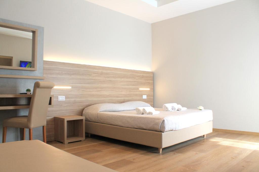 Hotel Sanremo في ريميني: غرفة نوم عليها سرير وفوط