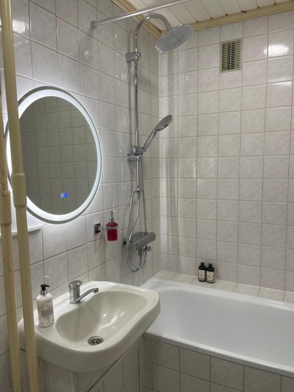 a bathroom with a sink and a tub and a mirror at ROTUŠĖS g 23 APARTMENTS IN THE CITY CENTER BIRŽAI in Biržai