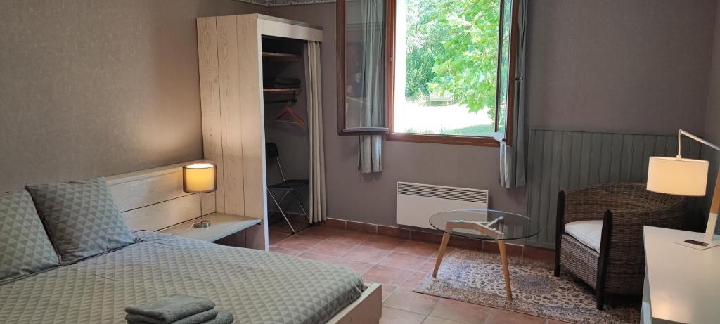 a bedroom with a bed and a table and a window at B&B Auberge Verdon in La Palud-sur-Verdon