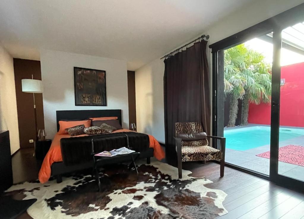 a bedroom with a bed and a balcony with a pool at La Maison Courtois in Cholet