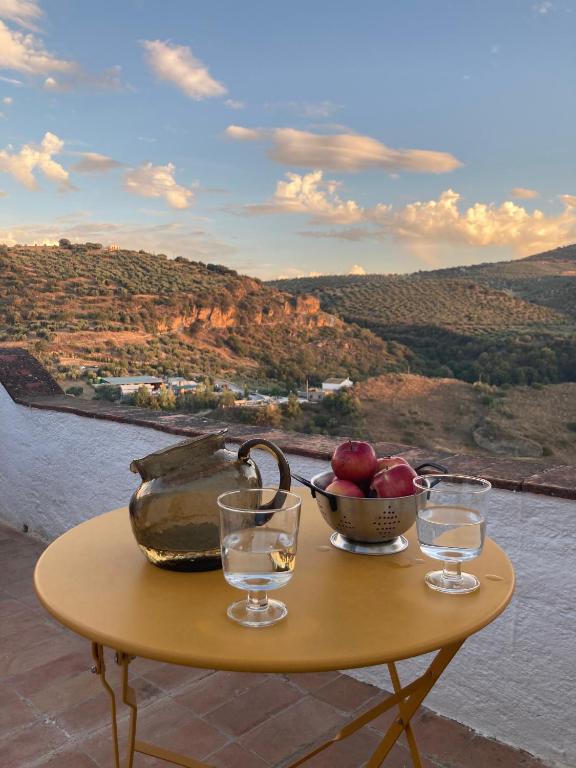 a table with two glasses and a bowl of fruit at Las casillas de la Villa: SOLEÁ in Montefrío