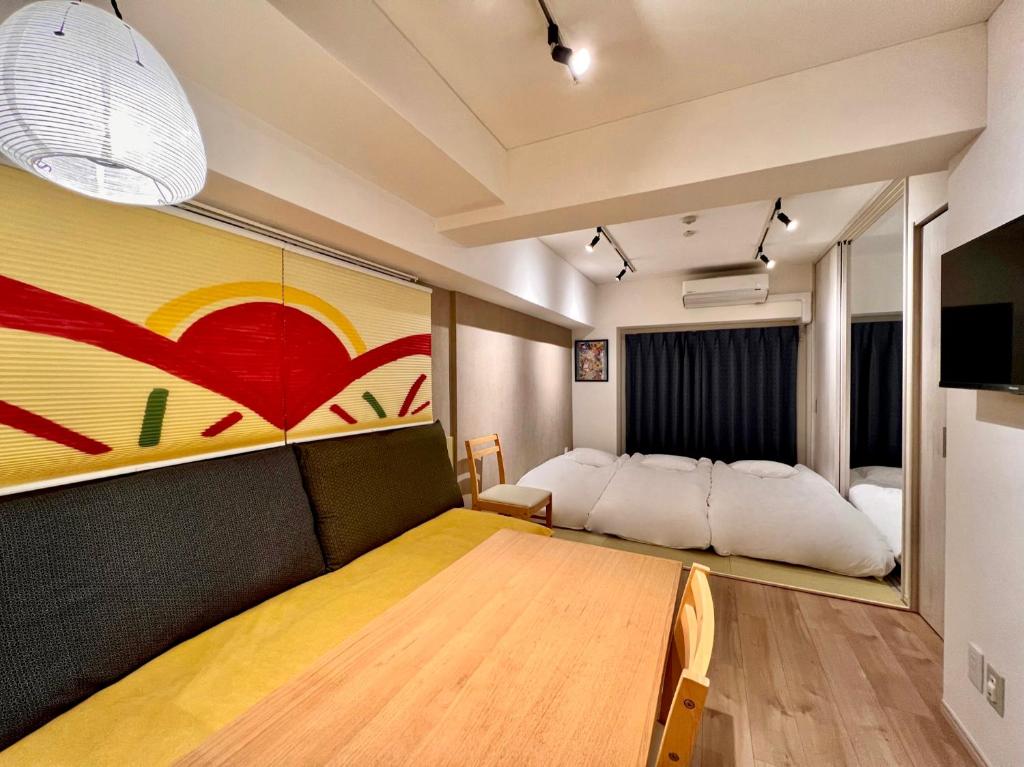 a room with a dining table and a bed at 浅草寺3分 浅草駅6分 2寝室+リビング2-6人 スカイツリービュー 駅近 成田空港&羽田空港直通 in Tokyo