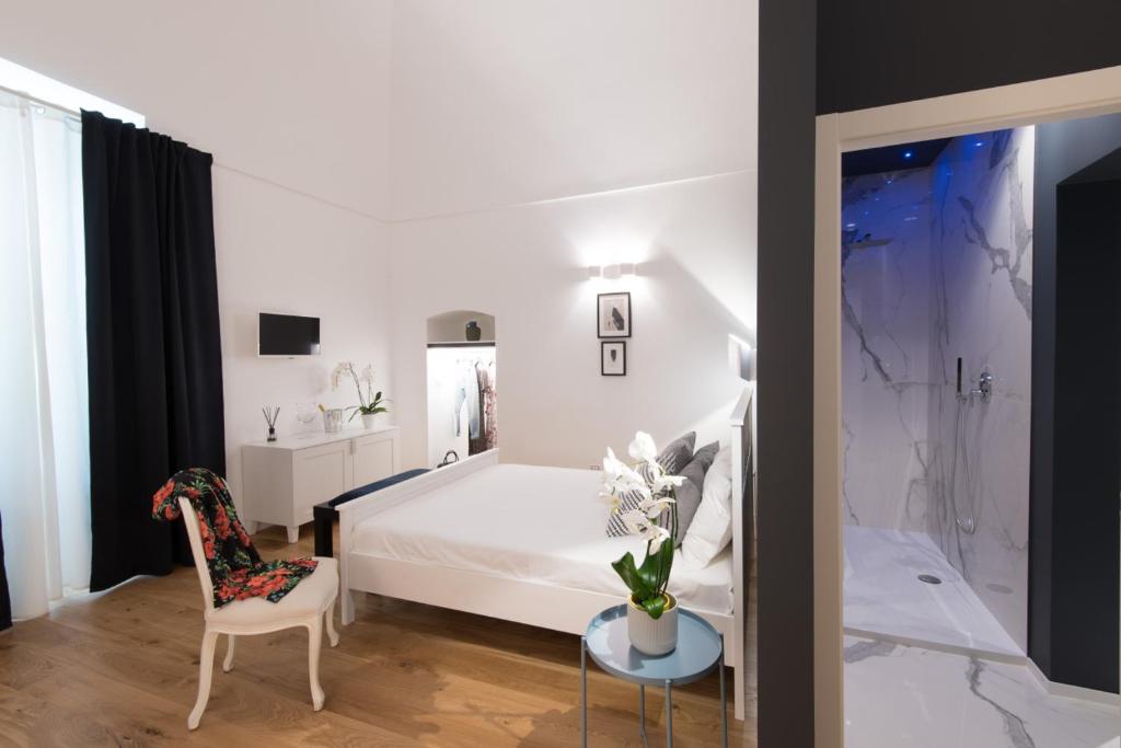 a bedroom with a bed and a table and a chair at I Colori della Puglia Rooms in Trani