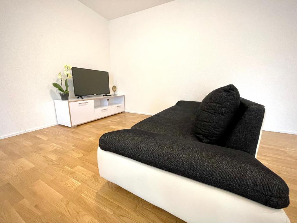 a living room with a couch and a flat screen tv at Apartment am Weinberg in Remshalden