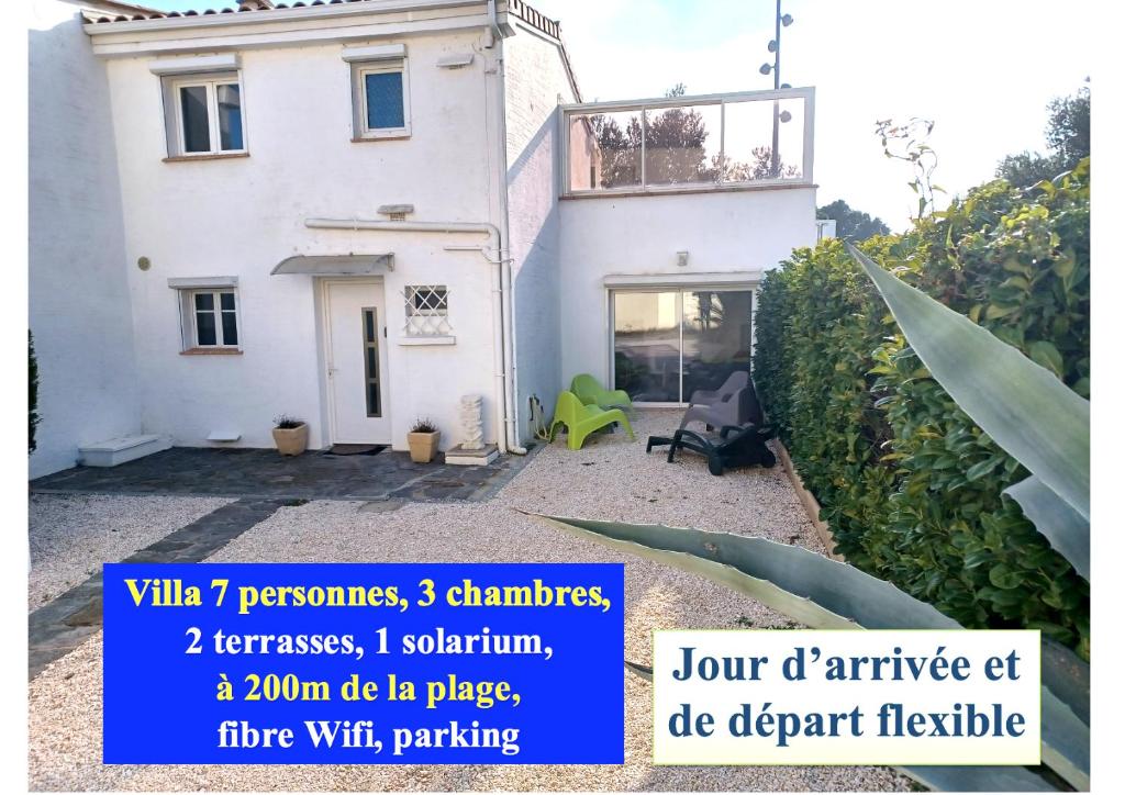 a large white house with a sign in front of it at Côte Indigo - Villa 7 personnes, 3 chambres, 3 terrasses - à 150 de la mer in Saint Pierre La Mer