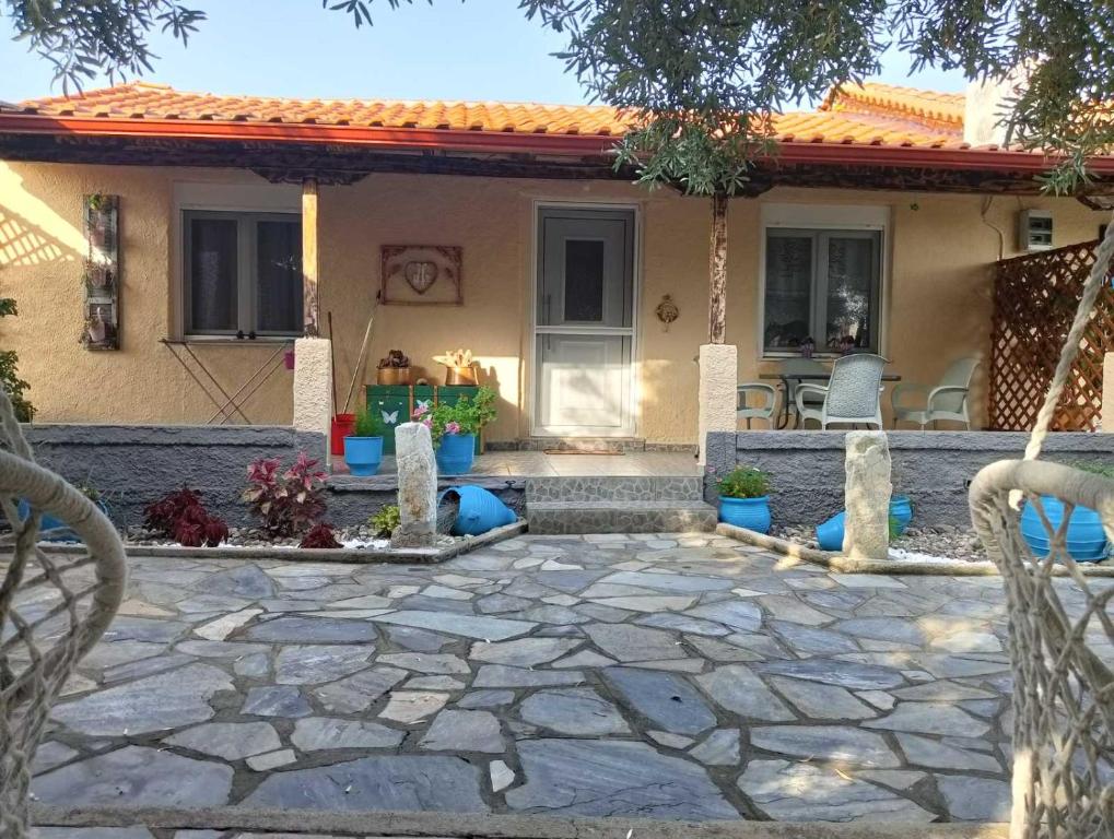 a house with a stone patio in front of it at Housebutterfly in Toroni
