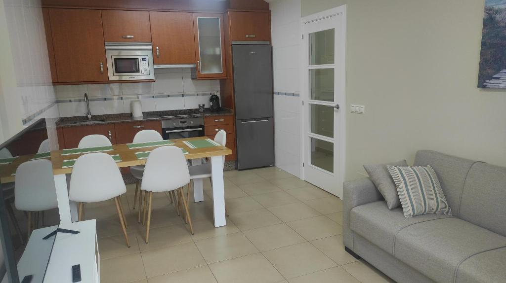 cocina con mesa, sillas y sofá en Amaral Miramar, en Boiro