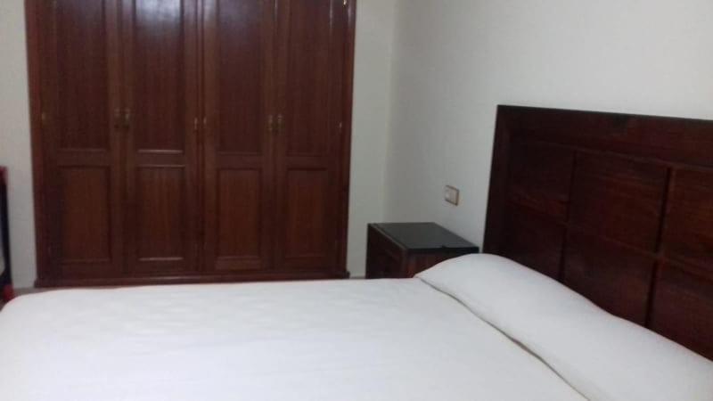 1 dormitorio con cama blanca y armarios de madera en إقامة للعطلة على بعد 200 متر من البحر en Nador