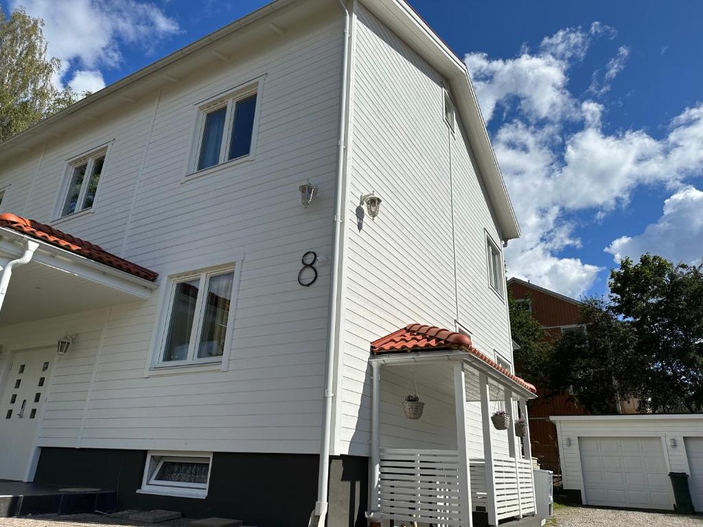 Uma casa branca com uma porta ao lado. em Nyrenoverat boende i villaområde em Gävle