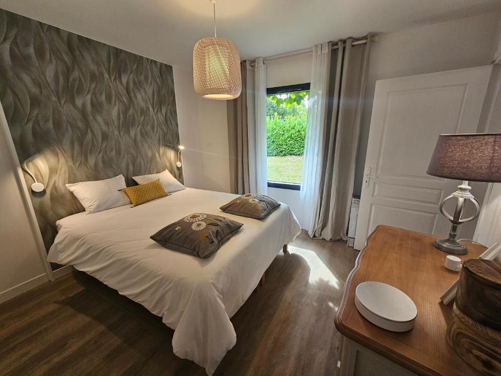1 dormitorio con cama, escritorio y ventana en La Crocherie : Gîte des Elfes - Free Wifi & Smart TV, en Beaumont-Pied-de-Boeuf